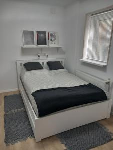 考波什堡的住宿－Zárda utcai Apartman，白色卧室内的一张床位,配有黑色毯子