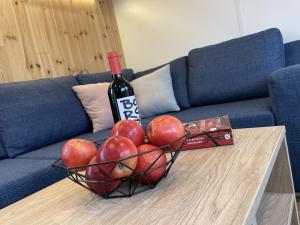 kosz jabłek i butelka wina na stole w obiekcie Holiday Home Tiny Haus Altmühlblick II by Interhome w mieście Riedenburg