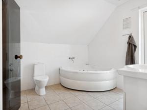 baño blanco con bañera y aseo en Holiday Home Tian in SE Jutland by Interhome, en Gjern