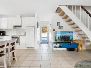 a kitchen with white cabinets and a staircase at Holiday Home Tian in SE Jutland by Interhome in Gjern