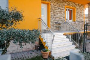 a staircase leading to a house with an orange wall at Lara’s House in San Giovanni Lupatoto