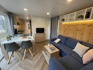 a living room with a blue couch and a table at Holiday Home Tiny Haus Rotkehlchen by Interhome in Riedenburg
