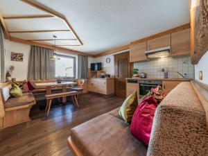 cocina y sala de estar con sofá y mesa en Apartment Haus Schöser by Interhome en Hippach