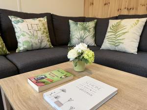 a coffee table with books and flowers on a couch at Holiday Home Paul by Interhome in Wemding
