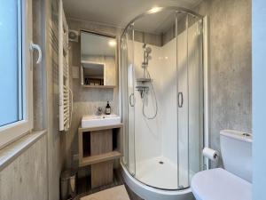 ein Bad mit einer Dusche und einem Waschbecken in der Unterkunft Holiday Home Tiny Haus mit schönem Seeblick by Interhome in Wemding