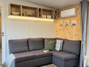 ein Wohnzimmer mit einem Sofa in einem Zimmer in der Unterkunft Holiday Home Tiny Haus mit schönem Seeblick by Interhome in Wemding