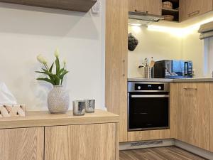 een keuken met houten kasten en een zwarte oven bij Holiday Home Eule by Interhome in Wemding