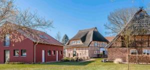 a group of three houses with a red building at HofGut Bockelkathen Tiny Haus 10 in Lüdersburg