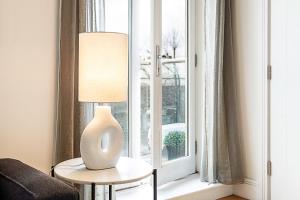 a lamp sitting on a table next to a window at Tranquil Belsize Park Haven with Stunning Views in London