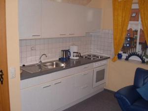 a kitchen with a sink and a counter top at Ferienwohnungen Tovar in Carolinensiel