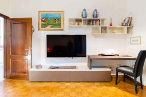 a living room with a desk and a large screen tv at sunny courtyard in Piombino