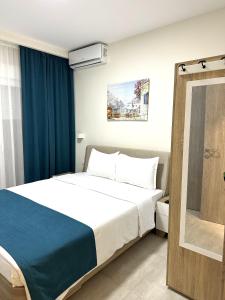 ペライアにあるNavarino Luxe Suites with Sea Viewのベッドルーム(ベッド1台、青いカーテン付)