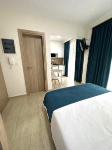 a hotel room with a bed and a kitchen at Navarino Luxe Suites in Perea