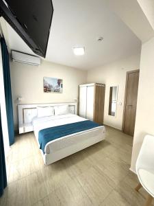 a bedroom with a large bed with a blue blanket at Navarino Luxe Suites in Perea