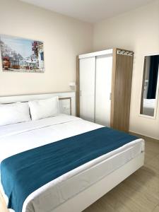 a bedroom with a large bed with a blue blanket at Navarino Luxe Suites in Perea
