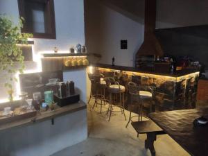 a bar in a restaurant with chairs and a counter at Chalé Canastra Zoo in Capitólio