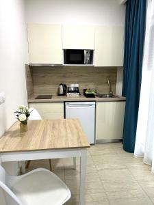 a small kitchen with a table and a microwave at Navarino Luxe Suites in Perea