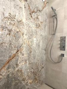 uma casa de banho com um chuveiro e uma parede de pedra em Wonderful cosy apartment in St. Moritz em St. Moritz