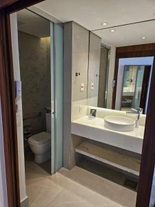 a bathroom with a sink and a toilet and a mirror at Hotel Nacional in Rio de Janeiro