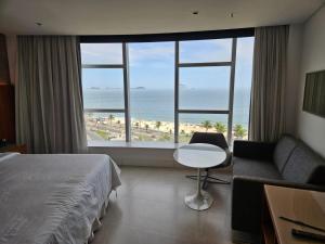 a hotel room with a bed and a view of the ocean at Hotel Nacional in Rio de Janeiro