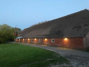 un edificio de ladrillo con luces en el lateral. en Gulfhof Friedrichsgroden, en Carolinensiel