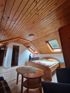 1 dormitorio con cama y techo de madera en Hostinec Staré Hory, en Staré Hory