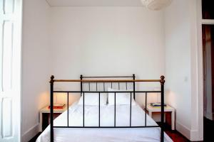 リスボンにあるCasa da Laranjeiraのベッドルーム1室(黒い二段ベッド1組、2泊用スタンド付)