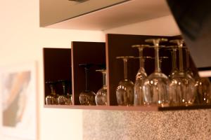 a shelf filled with wine glasses on a wall at Tullius Die Rebmeisterei in Bad Sobernheim