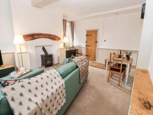 a living room with a green couch and a table at Natland Hall Cottage in Kendal