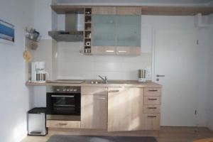 a kitchen with a sink and a stove at Ferienwohnung Johanne in Carolinensiel