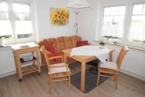 a living room with a table and chairs and a couch at Ferienwohnung Johanne in Carolinensiel