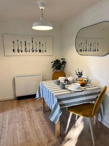 a dining room table with a blue and white striped table cloth at Purfleet Apartment-Free Parking in Purfleet