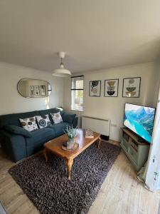 a living room with a blue couch and a table at Purfleet Apartment-Free Parking in Purfleet