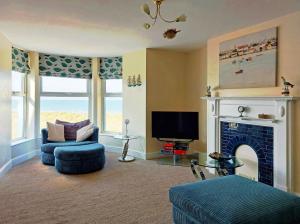 a living room with a fireplace and a tv at Hafan Y Traeth Beach Front Apartment in Barmouth in Barmouth