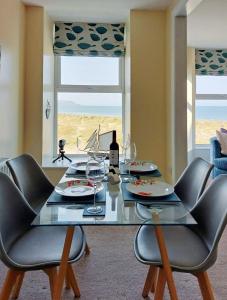 a dining room with a glass table and chairs at Hafan Y Traeth Beach Front Apartment in Barmouth in Barmouth