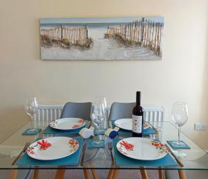 a dining room table with a bottle of wine and glasses at Hafan Y Traeth Beach Front Apartment in Barmouth in Barmouth