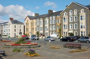 a parking lot with cars parked in front of buildings at Hafan Y Traeth Beach Front Apartment in Barmouth in Barmouth