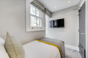 a small bedroom with a bed and a window at Mornington Hotel London Victoria in London