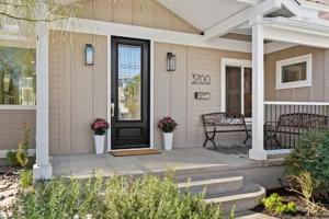 una casa con una porta nera e una panchina sul portico di Champagne Taste Luxury Home in Hillcrest a San Diego