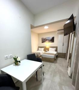 a hotel room with a bed and a table and a room at Navarino Luxe Suites in Perea
