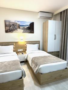two beds in a hotel room with a bedroom at Navarino Luxe Suites in Perea