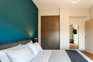a bedroom with a bed with a blue wall at Minimal Loft Art with Sea View Over Heraklion Harbour in Heraklio
