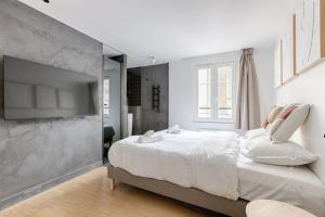 a bedroom with a large bed with white sheets at MyKeypers - Luxury Design Flat 2BR/6P - Rue de Charonne ! in Paris