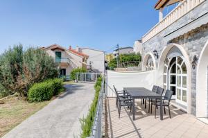 um pátio com uma mesa e cadeiras num edifício em Luxury apartment with pool large patio & sea view em Omiš