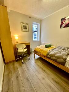 sypialnia z łóżkiem, biurkiem i krzesłem w obiekcie Bethnal Green Rooms R5 w Londynie