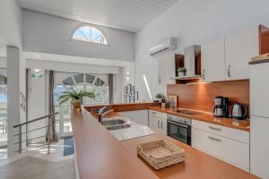 uma cozinha com armários brancos e um lavatório em Luxury apartment with pool large patio & sea view em Omiš