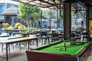 a pool table in a restaurant with tables and chairs at Sea Beach Hostel & Club AoNang Beachfront in Ao Nang Beach