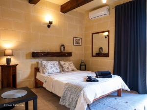 - une chambre avec un lit et un miroir dans l'établissement IL Gnejna II, à Ix-Xagħra