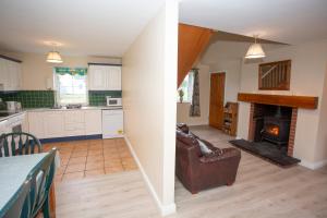 a kitchen and a living room with a fireplace at Brittas Bay Holiday Village No 32 in Brittas Bay