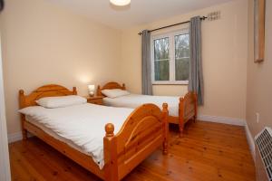 two twin beds in a room with a window at Brittas Bay Holiday Village No 32 in Brittas Bay